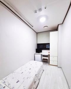 a bedroom with a bed and a desk at Coem Livingtel in Goyang