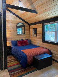 a bedroom with a bed in a wooden cabin at Cozy Log Tiny Cabin in Red River Gorge! in Campton
