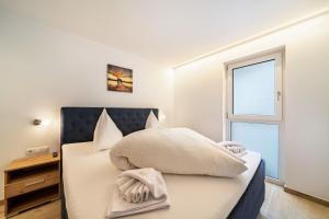 a bedroom with a bed with white sheets and a window at Ferienwohnung Lamm 1 in San Valentino alla Muta