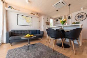 een woonkamer met een bank en een tafel en stoelen bij BUQEZ VILLAS - VILLA 78 in Drage