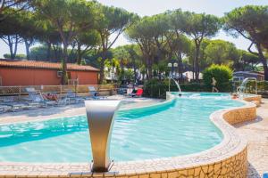 ein Pool in einem Resort mit einer Person im Hintergrund in der Unterkunft Gitavillage Il Gabbiano in Albinia