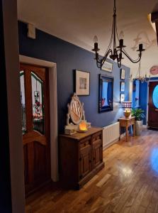 a living room with blue walls and a chandelier at Forest View Dunmore Galway H54P897 in Dunmore