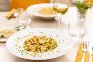 阿爾比尼婭的住宿－Gitavillage Il Gabbiano，桌上的白盘食物和酒杯