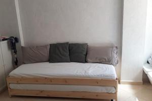Bett mit weißer Bettwäsche und grauen Kissen in einem Zimmer in der Unterkunft la maison du repos in Oulad Kerroum