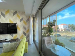 a living room with a glass table and a tv at Luxury Apartment Port of Jaffa in Tel Aviv