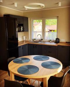 a kitchen with a wooden table with four blue mats on it at Apartament Nadwodnia 37 in Łapsze Niżne