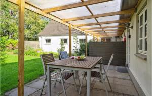 a patio with a table and chairs under a pergola at Amazing Apartment In Ringkbing With Wifi in Ringkøbing