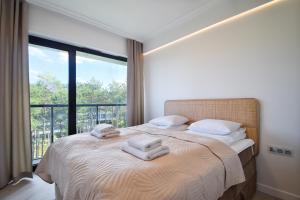 - une chambre avec un grand lit et des serviettes dans l'établissement RentPlanet - Apartamenty Shellter, à Rogowo
