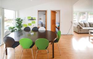 uma mesa de jantar com cadeiras verdes numa sala de estar em Beautiful Home In rsted With Kitchen em Kare