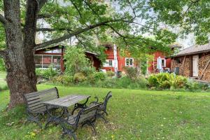 a park bench sitting next to a tree in a yard at Charming holiday home in Kungsgarden, Gastrikland in Kungsgården