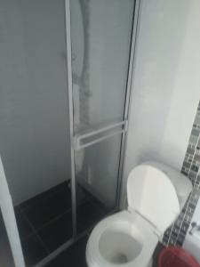 a bathroom with a toilet and a glass shower at CLUB CAMPESTRE EL DESPERTAR DE LAS AVES 