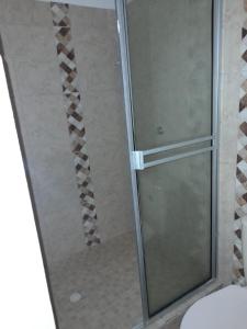W łazience znajduje się prysznic ze szklanymi drzwiami. w obiekcie CLUB CAMPESTRE EL DESPERTAR DE LAS AVES 