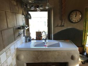 a kitchen with a sink and a clock on the wall at La Boutique Naturelle in Vresse-sur-Semois