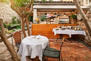 a restaurant with two tables and chairs and a counter at Angelo d'Oro Heritage Hotel in Rovinj