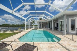 a swimming pool in a house with a glass ceiling at Heaven Found! Stunning River Views & Pool - Villa Island Sunset - Roelens Vacations in Fort Myers