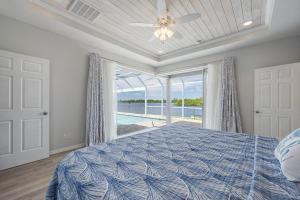 a bedroom with a bed and a large window at Heaven Found! Stunning River Views & Pool - Villa Island Sunset - Roelens Vacations in Fort Myers