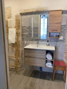 ein Bad mit einem Waschbecken und einem Spiegel in der Unterkunft La maison des Consuls in Auxerre