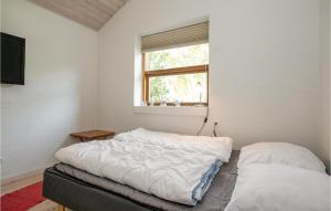 HelberskovにあるNice Home In Hadsund With 3 Bedrooms, Sauna And Wifiのベッドルーム1室(ベッド2台、窓付)