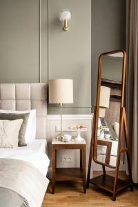 a bedroom with a mirror and a table with a lamp at Avanti Palazzo in Krakow