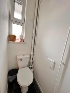Elle comprend une petite salle de bains pourvue de toilettes et d'une fenêtre. dans l'établissement Rooms in Bethnal Green, à Londres