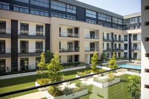 an apartment building with a courtyard with a swimming pool at Cosy 1 Bed Loft @Embassy Gardens in Cantonments