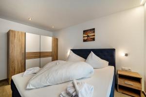 1 dormitorio con 1 cama grande con sábanas blancas en Ferienwohnung Lamm 3 en San Valentino alla Muta