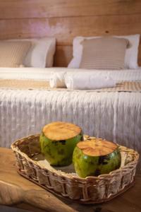 two coconuts in a basket on a table next to a bed at Mansur Hotelaria de Charme in Luis Correia