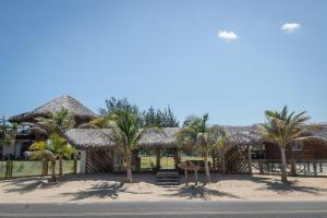 a resort with palm trees on the side of the road at Mansur Hotelaria de Charme in Luis Correia