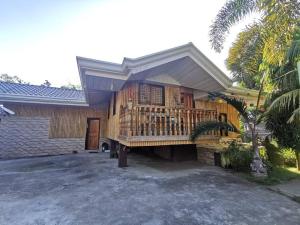 a house with a wooden deck on a driveway at Josephine's Villa - Bangar, LU (up to 15 guests) in Bangar