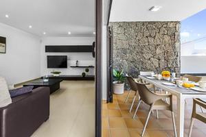 een woonkamer en een keuken met een tafel en stoelen bij Casa Airalba in Tías