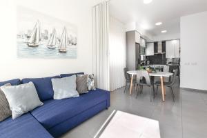 ein Wohnzimmer mit einem blauen Sofa und einem Tisch in der Unterkunft Casa Brilhante - Sunny Delight in Nazaré