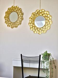 dos espejos en una pared junto a un escritorio con una silla en Casa Elena by TraMonti Apartments en LʼAquila