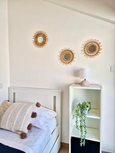 sypialnia z 2 lustrami na ścianie i łóżkiem w obiekcie Casa Elena by TraMonti Apartments w mieście LʼAquila