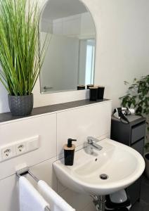 a white bathroom with a sink and a mirror at Ferienwohnung an der Steinfurter Aa in Steinfurt +33 photos
