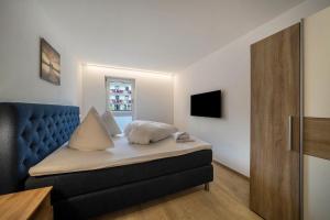 a bedroom with a bed with a blue head board at Ferienwohnung Lamm 4 in San Valentino alla Muta