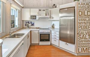 a kitchen with white cabinets and a stainless steel refrigerator at Beautiful Home In Asperup With 4 Bedrooms, Sauna And Wifi in Asperup