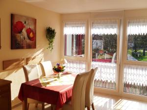 a dining room with a table and chairs and windows at Domizil Rupertuspark in Bad Reichenhall