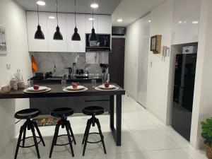 a kitchen with a black island with bar stools at Element by Elite, departamento de lujo in Santa Cruz de la Sierra