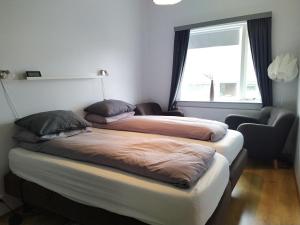 2 Betten in einem Zimmer mit Fenster in der Unterkunft Flateyri guesthouse in Flateyri