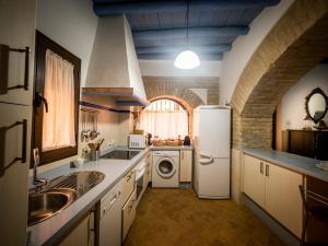 una cucina con frigorifero bianco e lavandino di Fabulosa, Casa Mudéjar. Centro Histórico. a Carmona
