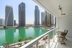 a balcony with a view of a river in a city at StoneTree - 1BR apartment with Lake View in Dubai