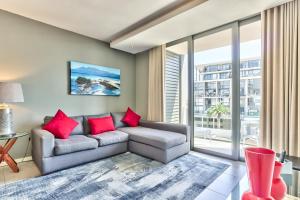 a living room with a couch and a large window at Chelsea on Main in Cape Town