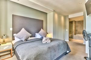 a bedroom with a large bed with two towels on it at Chelsea on Main in Cape Town