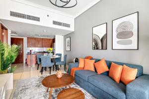 a living room with a blue couch and a table at StoneTree - 1BR apartment with Lake View in Dubai