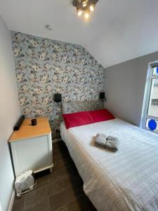 Schlafzimmer mit einem Bett mit einem roten Kissen und einem Tisch in der Unterkunft Parnell Place Apartments in Dublin