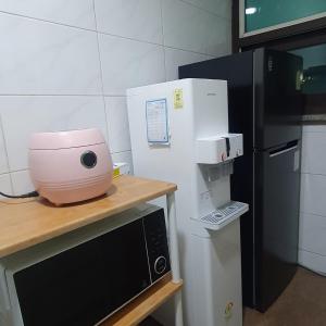a kitchen with a mixer on a counter next to a refrigerator at Coem Livingtel in Goyang