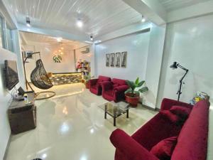 a living room with red couches and a tv at JL Valley Suites in Cauayan City