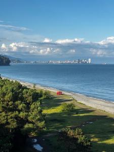 een strand met een rode tent aan de oever van het water bij ORANGE INN in Chakvi