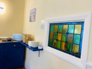 a kitchen with a stained glass window on the wall at Cwtch Guesthouse in Llandudno