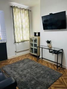 a living room with a flat screen tv on a wall at Coventry City House - Room 2 in Coventry